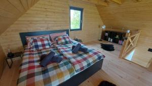 ein Schlafzimmer mit einem Bett in einer Holzhütte in der Unterkunft Z-Woods in Maklár