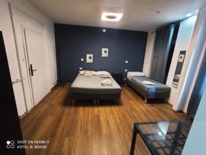 Cette petite chambre comprend deux lits et une table. dans l'établissement Hotel Brioni, à Trieste