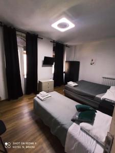 1 dormitorio con 2 camas y una luz en el techo en Hotel Brioni, en Trieste