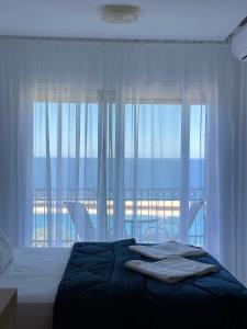 a bedroom with a bed and a large window at Villa Milan in Sveti Stefan
