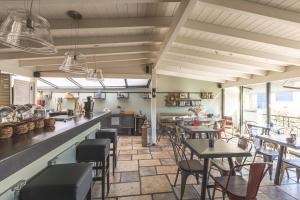 a restaurant with tables and chairs and a counter at Arethousa Hotel in Katakolo