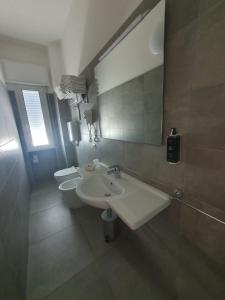 a bathroom with two sinks and a mirror and two toilets at Hotel Kursaal in Bellaria-Igea Marina +62 photos