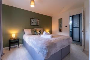 a bedroom with a large bed and two lamps at Spacious 3 Bed House, 5mins to HS2/ NEC/Airport. in Marston Green