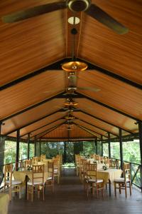 拉特納普勒的住宿－Sankara Resort，一间带桌椅和天花板的用餐室