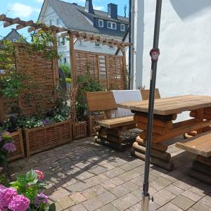 een patio met een houten tafel en een parasol bij Ferienhaus Usseln in Willingen