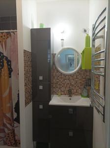 a bathroom with a sink and a mirror at appartement cosy à 200 du tram B chambre séparée Petite véranda lumineuse donnant sur jardinet in Pessac