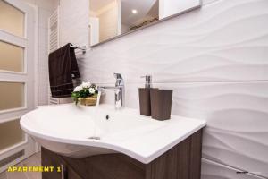 a white bathroom with a sink and a mirror at Residence 14 Sarajevo in Sarajevo