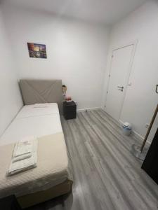 Kleines Zimmer mit einem Bett und einer Tür in der Unterkunft São Lázaro Bhuiyan Family Host in Lissabon