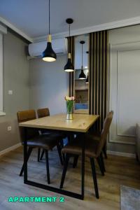 a dining room table with chairs and a vase of flowers on it at Residence 14 Sarajevo in Sarajevo