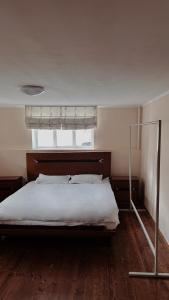 a bedroom with a bed and a window and a bed frame at 长城民宿34号院 in Almaty
