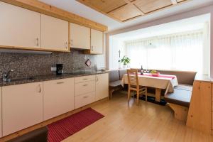 une cuisine avec une table et une salle à manger dans l'établissement Appartamenti Genziana, à La Villa