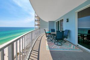 Un balcón con sillas, una mesa y el océano en Twin Palms 1601, en Panama City Beach