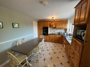 a kitchen with wooden cabinets and a table and chairs at Corrigs Retreat in Newcastle