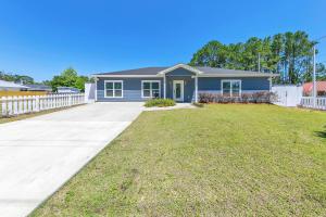 a blue house with a white fence at Rustic Oasis in Panama City Beach