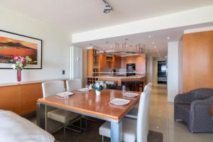 a dining room and kitchen with a wooden table and chairs at BEL AIR HOLIDAY - 3 Bedroom Apartment with Sauna and Phenomenal Sea View T72 in Ostend