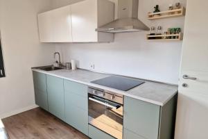 a kitchen with white cabinets and a stove top oven at Brescia Vibes in Brescia