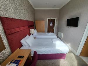 a hotel room with two beds and a table at Cliffe Norton in Tenby