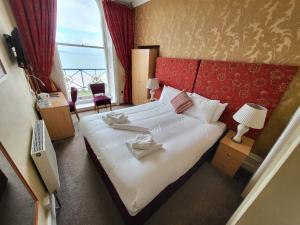 a bedroom with a large bed with a red headboard at Cliffe Norton in Tenby
