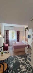 ein Schlafzimmer mit einem Bett und einem Tisch in einem Zimmer in der Unterkunft MUSES LUXURY SUITES in Korfu-Stadt