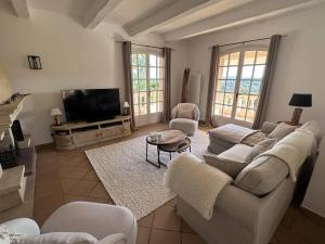 ein Wohnzimmer mit Sofa, Sesseln und Fernseher in der Unterkunft Maison avec Piscine Privée, Climatisation et Vue Mer - FR-1-768-69 in Saint-Peïre-sur-Mer