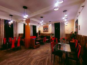 a restaurant with red chairs and tables in a room at Chetna hotel & cottage in Manāli