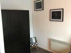 um quarto com um armário preto e duas fotografias na parede em Appartement Merville-Franceville-Plage, 2 pièces, 4 personnes - FR-1-465-108 em Merville-Franceville-Plage