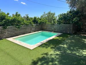 a swimming pool in a yard next to a fence at Chez François et Cécile in Figari