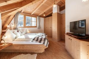 1 dormitorio con 1 cama grande y TV en Albert - Bon Di en Santa Cristina in Val Gardena