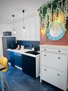 a kitchen with blue cabinets and a white counter top at Central Place to Stay in Reşiţa