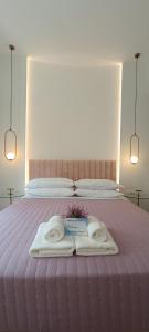 a bed with two towels and two books on it at MUSES LUXURY SUITES in Corfu Town