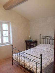 una camera da letto con un letto e una finestra di Maison de campagne La Teranga au coeur du Luberon ad Apt