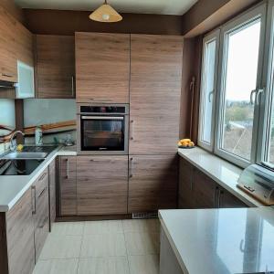 a kitchen with wooden cabinets and a microwave at ClickOnTheCozyLime room pokoje Czechów in Lublin