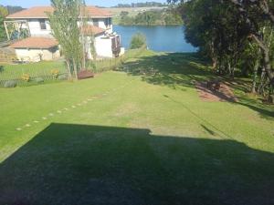 a large yard with a view of a lake at Emufuleni river logde in Vanderbijlpark