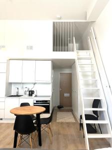 uma cozinha com uma mesa e cadeiras e uma escadaria em Scandinavian loft 1BR apartment near city centre em Turku
