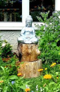 a statue of a buddha sitting on a tree stump at Room at Stockholm - Sweden in Stockholm