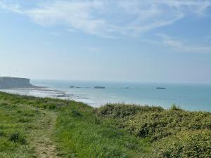 a dirt road next to the ocean with ships at Sereine d'Argouges in Bayeux +4 photos