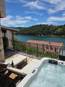 a hot tub on a patio with a view of a river at Apartments Mali Dvor Novigrad in Novigrad Dalmatia