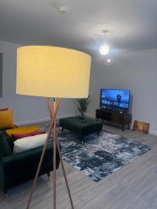 ein Wohnzimmer mit einem Sofa und einer Lampe in der Unterkunft Unique 2 bedroom Apartment 15 mins via tube to Central London in London