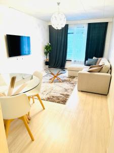 a living room with a couch and a table at Real deal apartments Tampere in Tampere