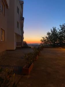 un edificio con una puesta de sol en el fondo en Sunny Home overlooking Tirana en Tirana