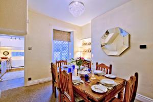 a dining room with a table with chairs and a mirror at Labernum Cottage, Ingleton Village, Yorkshire Dales National Park, Famous Three Peaks, Near The Lake District, Pets Are Welcome, Direct Parking in front of the Cottage & Guest Parking in Ingleton