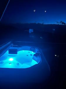 a jacuzzi tub with a blue light in the dark at Jahorina Luxury Chalets in Jahorina