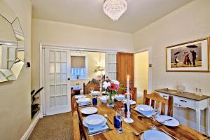 a dining room with a table with plates and flowers on it at Labernum Cottage, Ingleton Village, Yorkshire Dales National Park, Famous Three Peaks, Near The Lake District, Pets Are Welcome, Direct Parking in front of the Cottage & Guest Parking in Ingleton