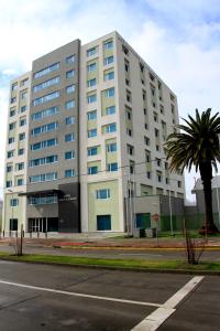 un gran edificio blanco con una palmera delante en Hotel Diego de Almagro Chillan, en Chillán