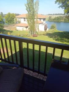 uma varanda com vista para um lago e uma casa em Emufuleni river logde em Vanderbijlpark