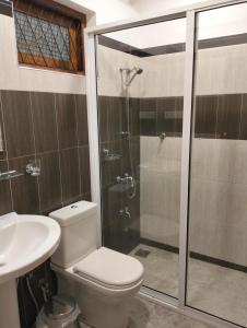 y baño con ducha, aseo y lavamanos. en Jacks Lounge and Hotel, en Kandy
