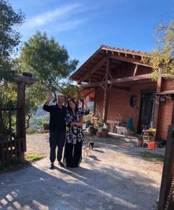 a man and a woman standing in front of a house at Room in Casa Castiglia a Woodhouse with Beautiful View close Madonie Park in Castelbuono