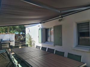 una mesa de madera y sillas en un patio en Villa Babeth by Nuits au Port en La Rochelle