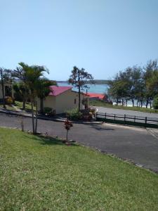 una carretera frente a una casa con una valla en CFM Sociedade Turística Bilene Resort en Vila Praia Do Bilene