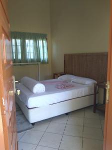 1 dormitorio con 1 cama con sábanas blancas y ventana en CFM Sociedade Turística Bilene Resort en Vila Praia Do Bilene